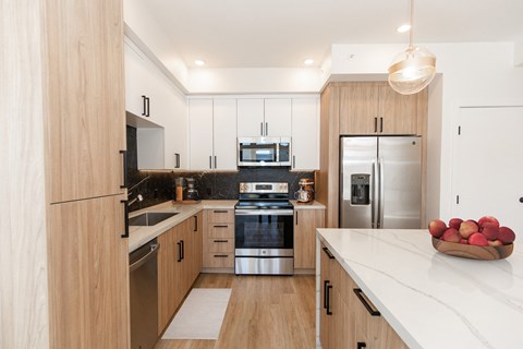 A modern kitchen with wooden cabinets and stainless steel appliances.