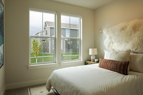 a bedroom with a bed and a large window