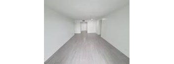 A long white hallway with a light at the end.