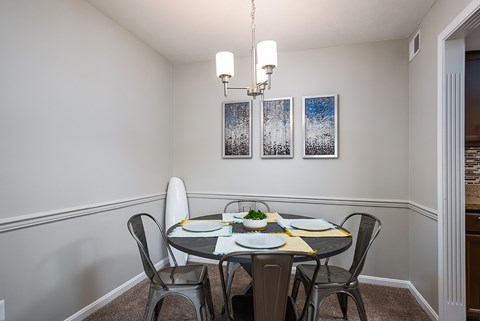 A dining room with a table set for two.