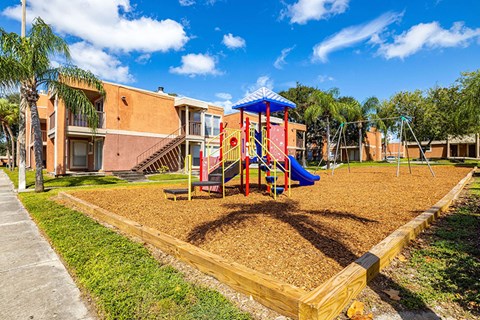 A playground with a slide and a wooden fence.