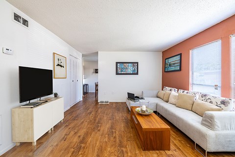 A living room with a white couch and a wooden coffee table.