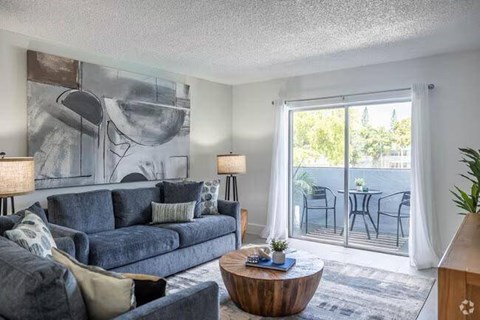 A living room with a grey couch and a wooden coffee table.