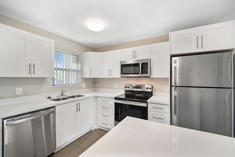 A kitchen with white cabinets and stainless steel appliances.