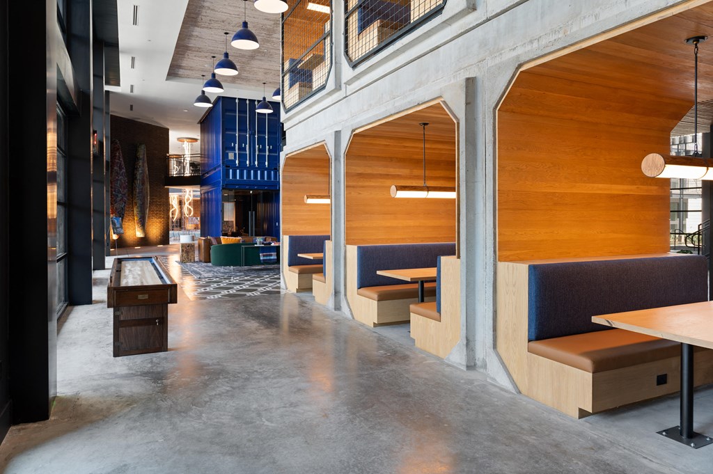 the lobby of a restaurant with wooden booths and tables