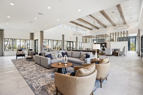 A spacious living room with a large rug and multiple seating options.