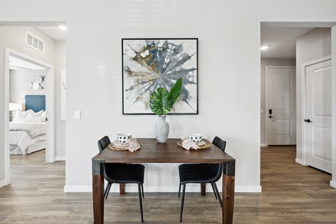 A dining room with a wooden table and chairs.