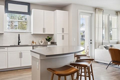 A kitchen with white cabinets and a grey countertop.