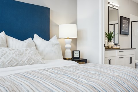 A bed with a blue headboard and white pillows.