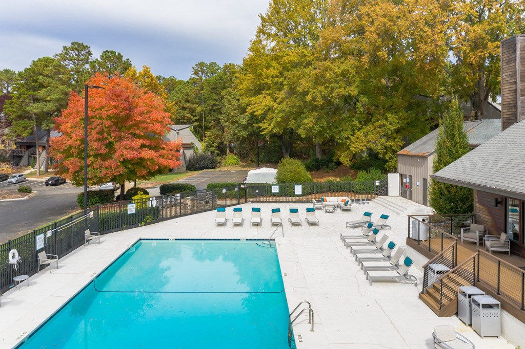 a swimming pool with lounge chairs next to a house