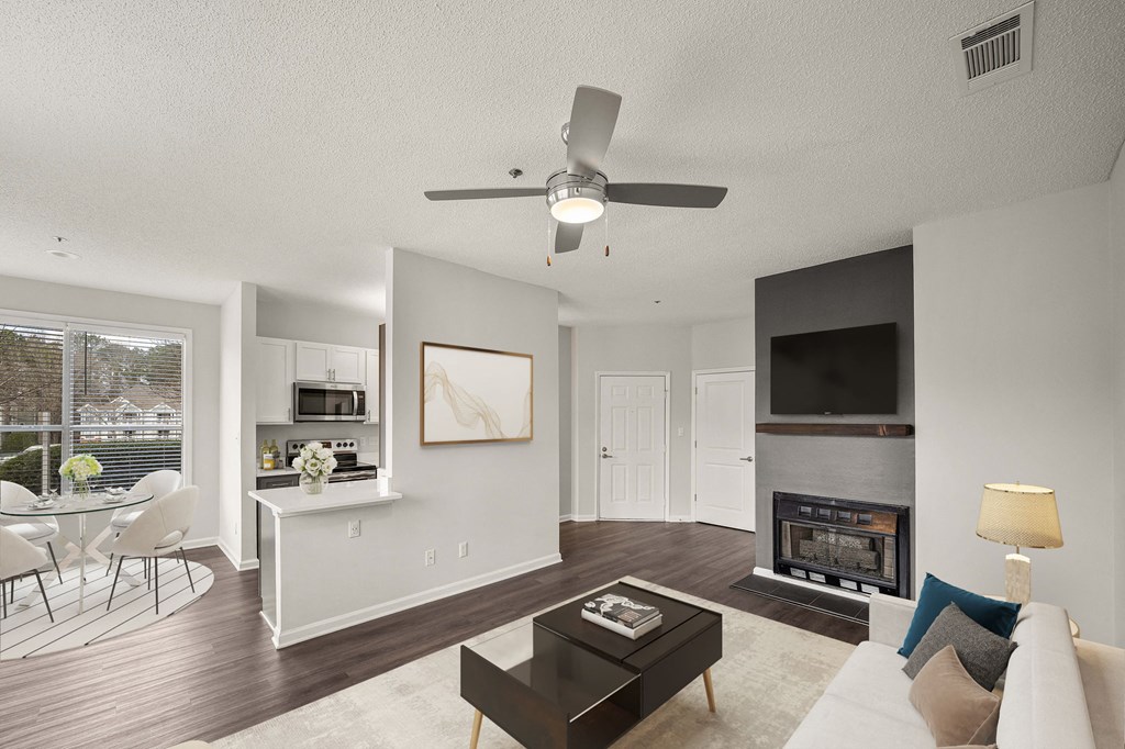 a living room with a fireplace and a ceiling fan