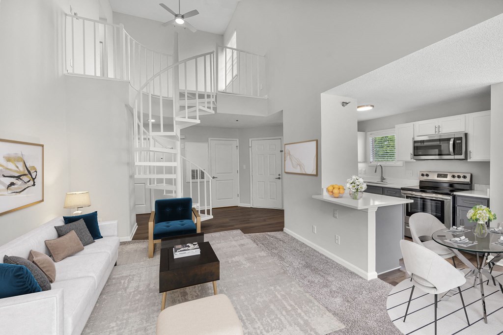 an open living room and kitchen with a spiral staircase