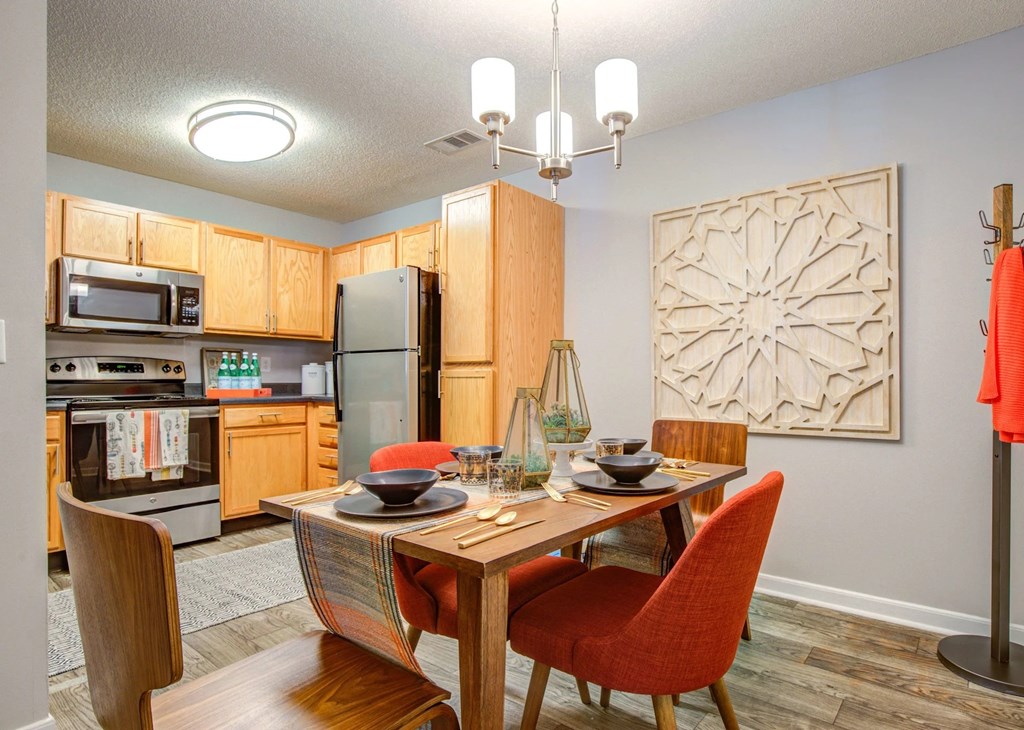 A kitchen with a dining table and chairs.
