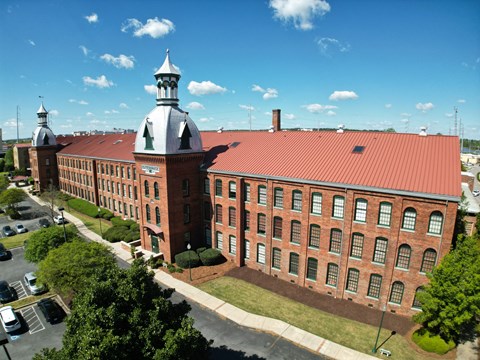 A large red brick building with a tower and a clock on the front.
