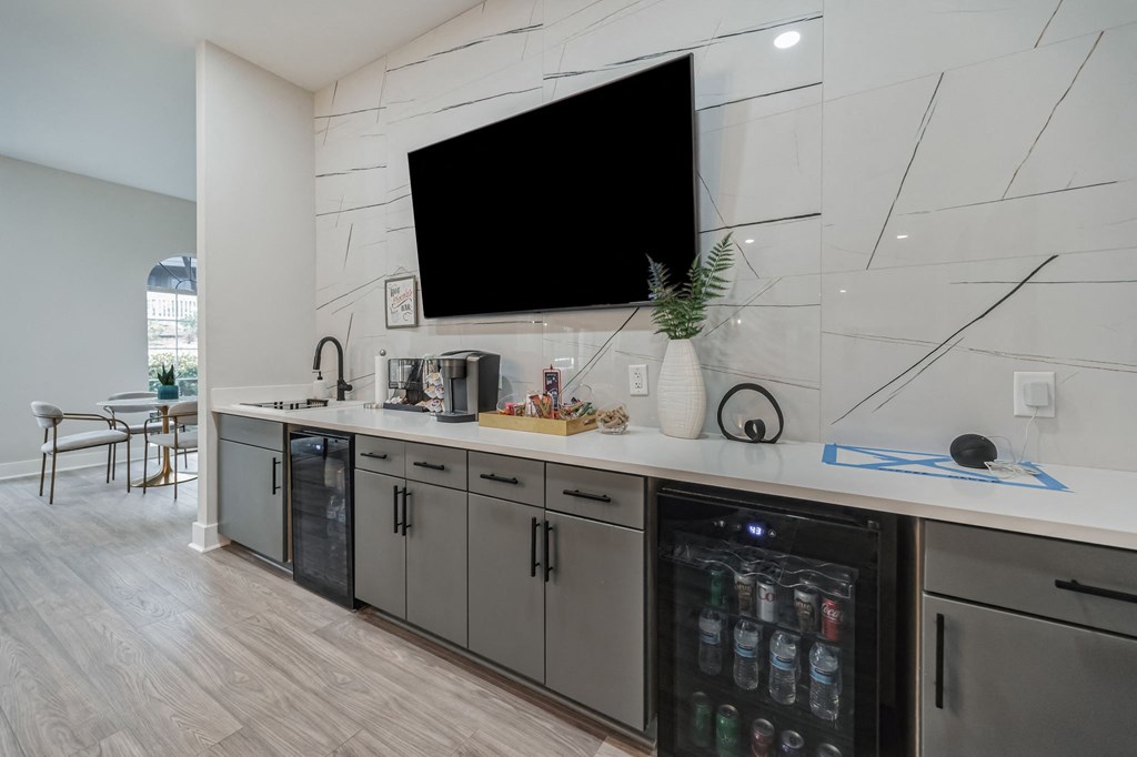 a large white kitchen with a large tv on the wall
