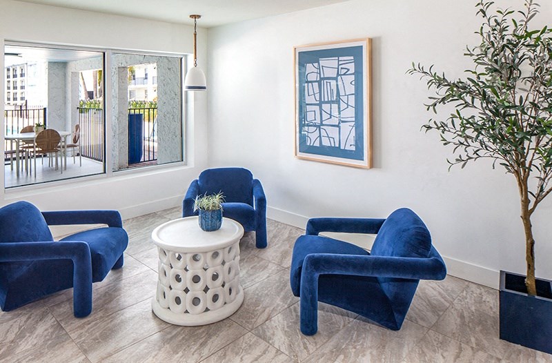 a living room with blue chairs and a white table