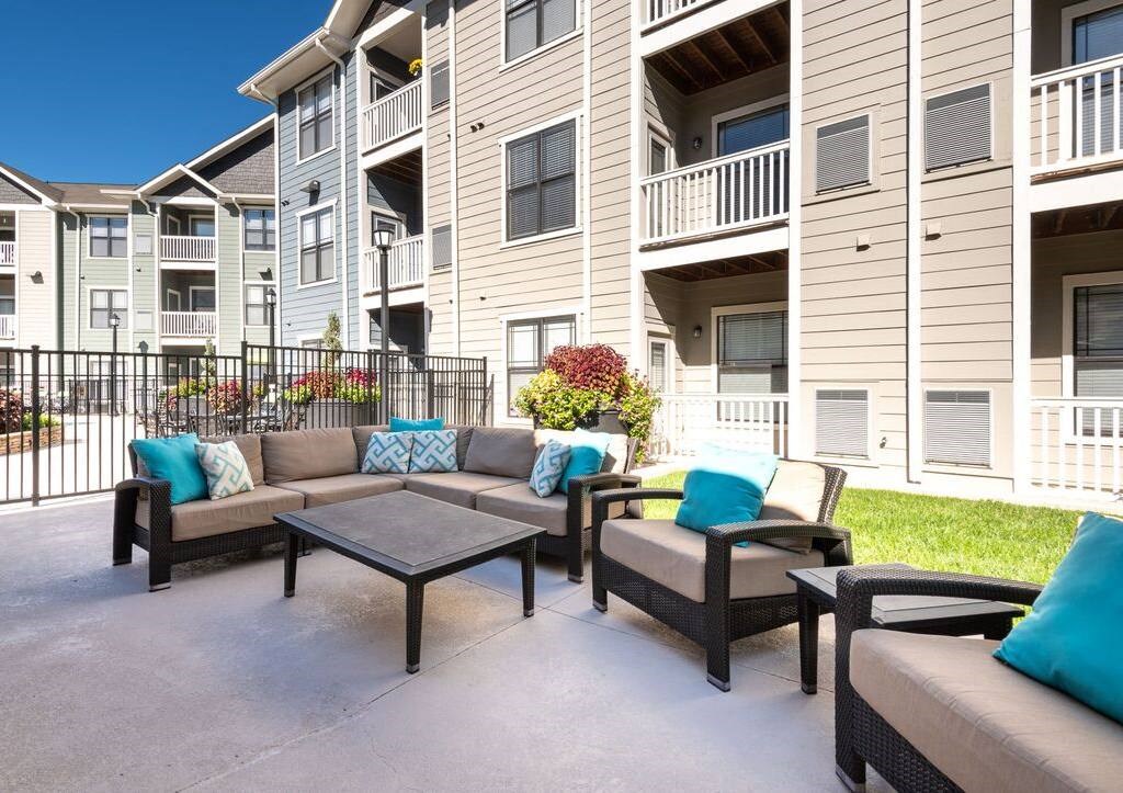 a patio with furniture in front of an apartment building