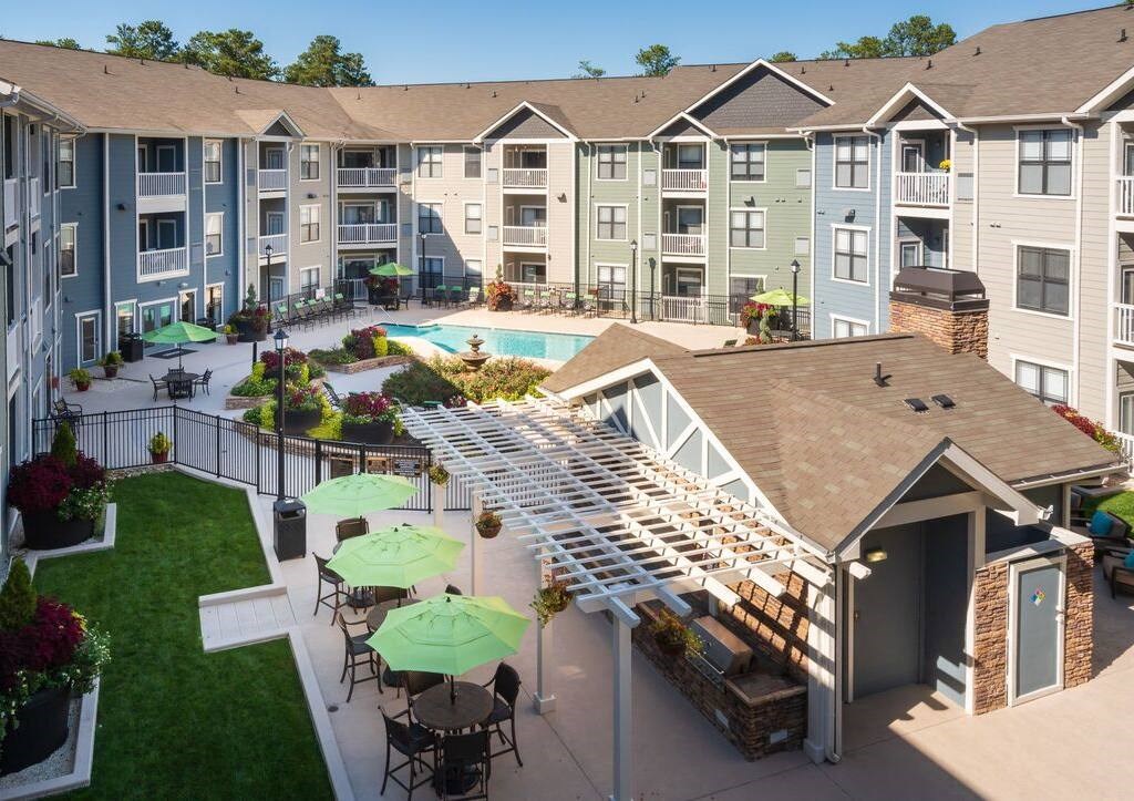 an aerial view of an apartment building with a pool and patio