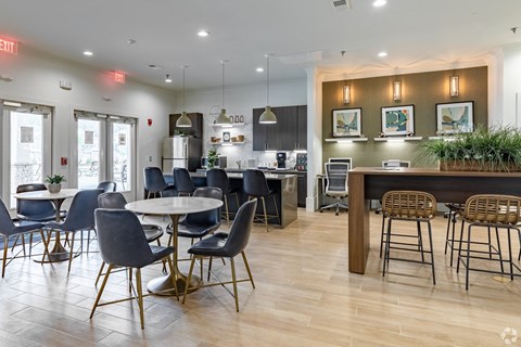 a clubhouse with tables and chairs and a kitchen
