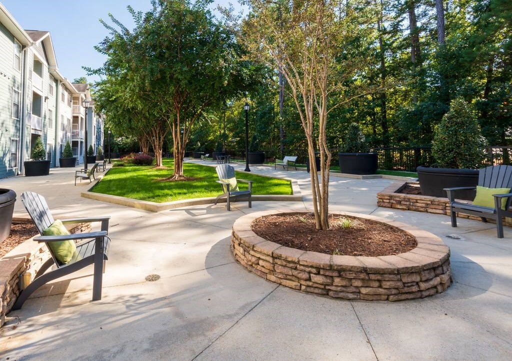 a park with benches and trees in front of a building