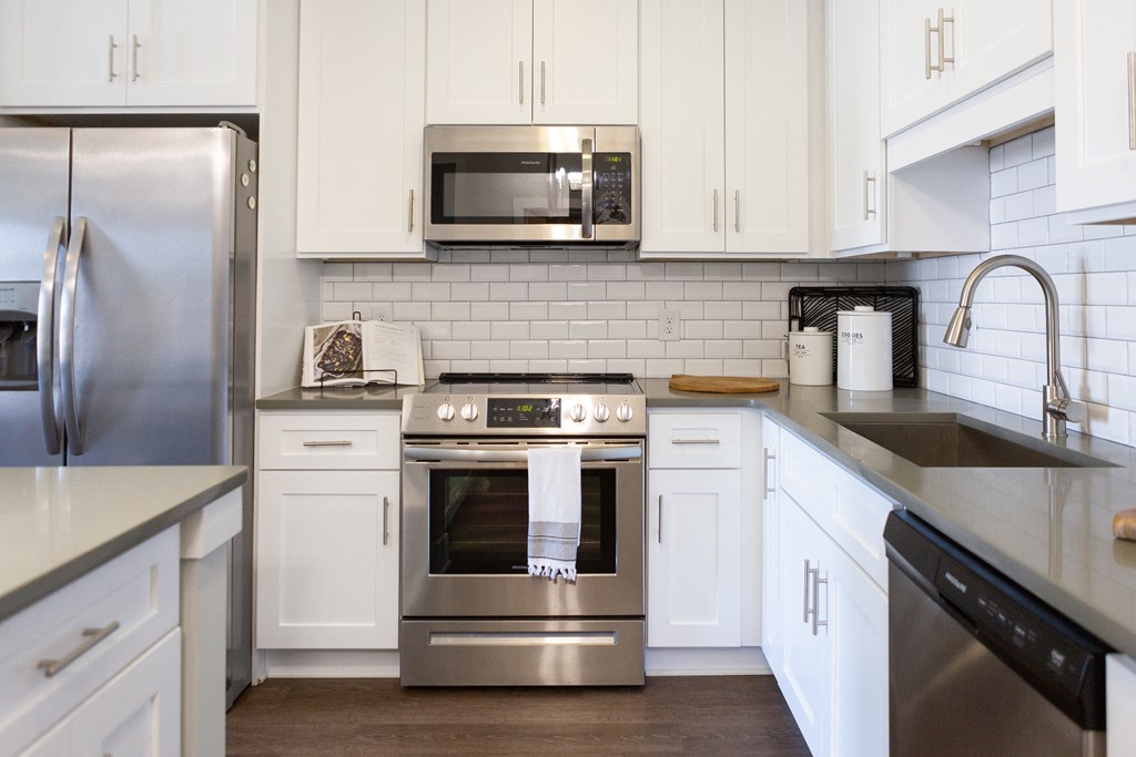 a kitchen with stainless steel appliances and white cabinets