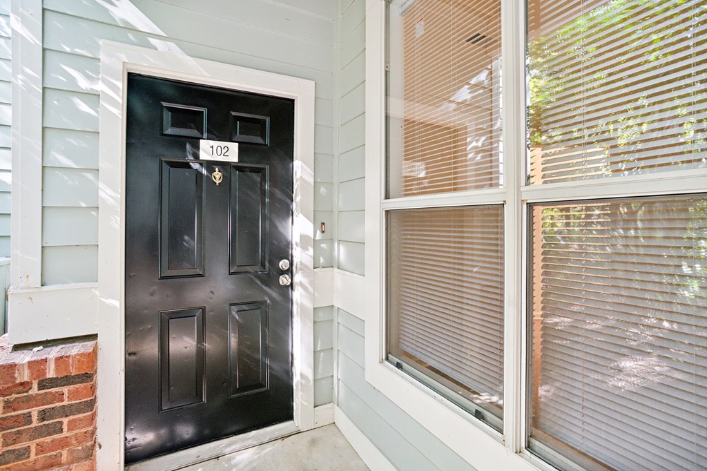 A black door with the number 102 on it.