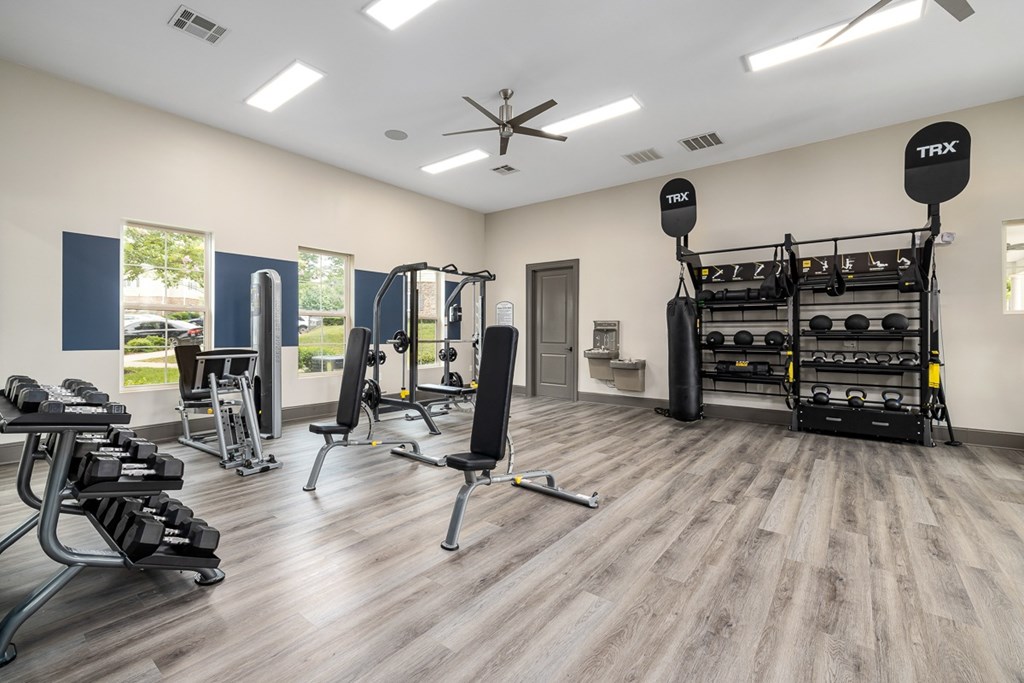 A TRX suspension trainer is hanging from the ceiling in a gym.