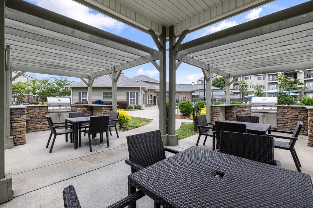 A patio with a table and chairs under a roof.