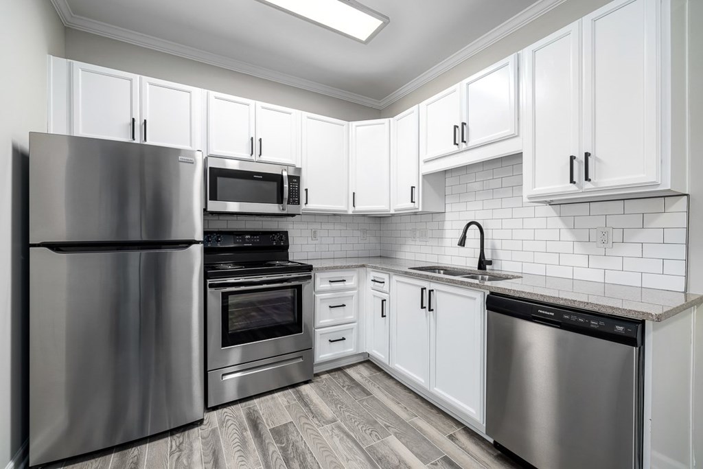 A modern kitchen with stainless steel appliances and white cabinets.
