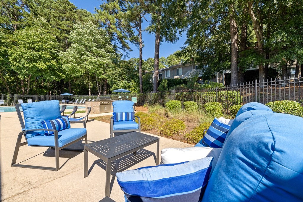 a furnished patio with blue chairs and a table