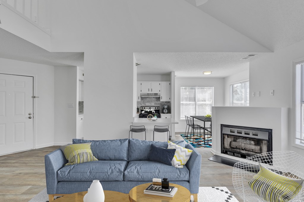 A living room with a grey couch and a fireplace.