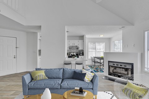 A living room with a grey couch and a fireplace.