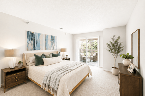 A bedroom with a large bed and a painting on the wall.