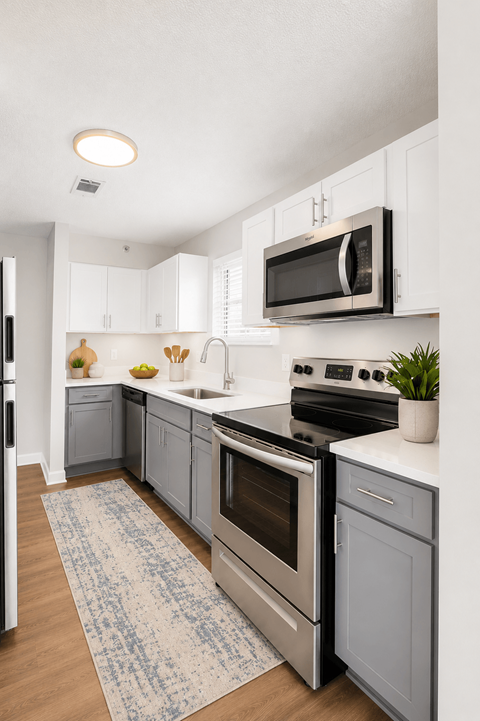 A kitchen with a stove top oven and a microwave above it.