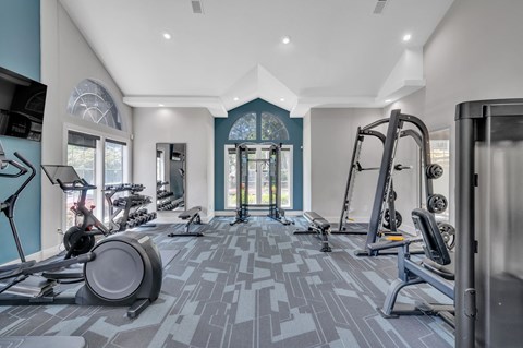 a gym with weights and cardio equipment in a room
