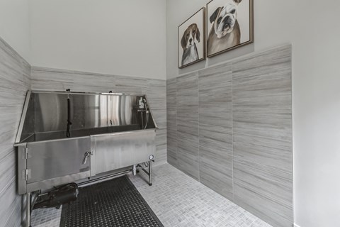 a large stainless steel sink in a bathroom with gray walls and tile flooring