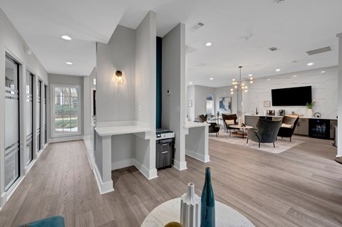a renovated living room and dining room with white walls and wood floors