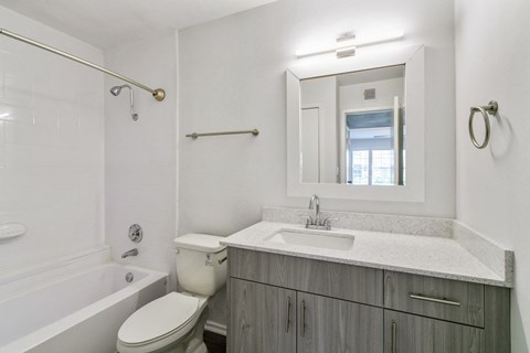 a bathroom with a sink toilet and tub and a mirror