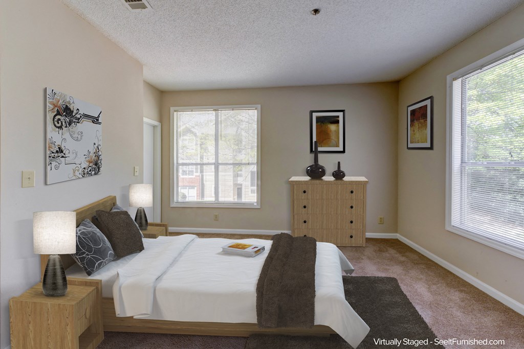 a bedroom with a bed and a dresser and two windows