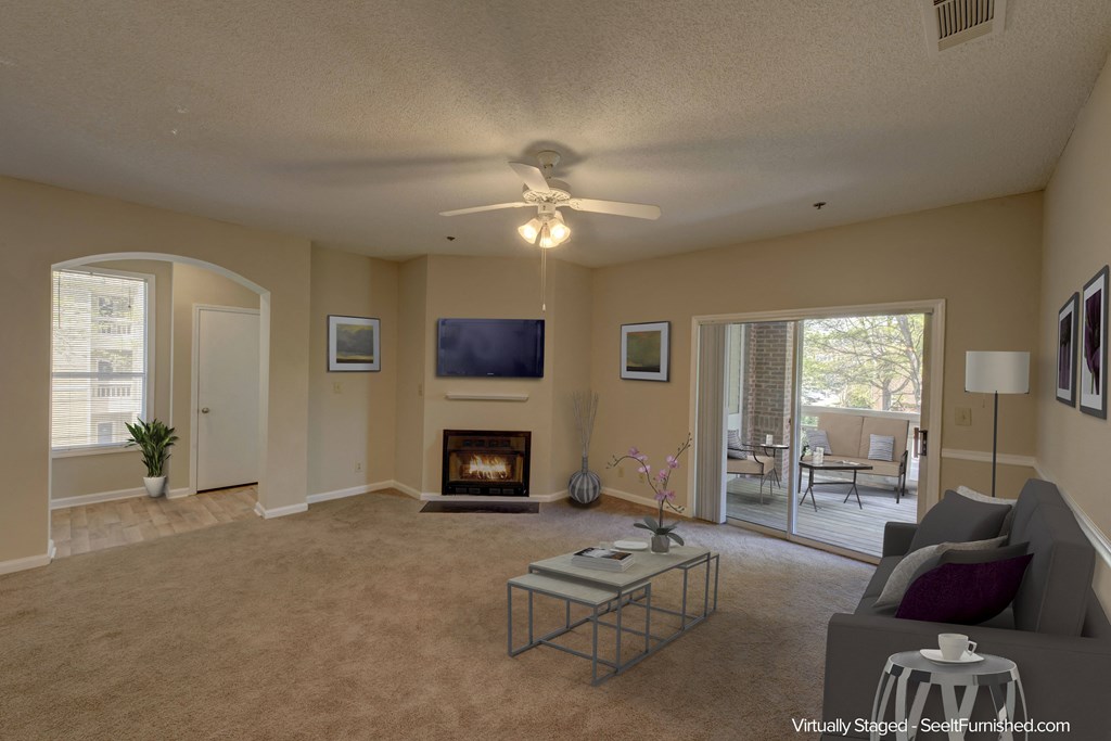a living room with a fireplace and a ceiling fan