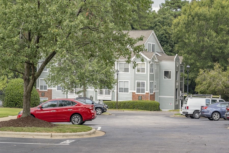 a red car parked in front of an apartment building