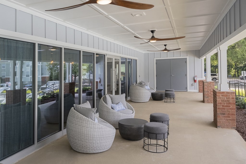 an outdoor patio with couches and chairs and glass doors
