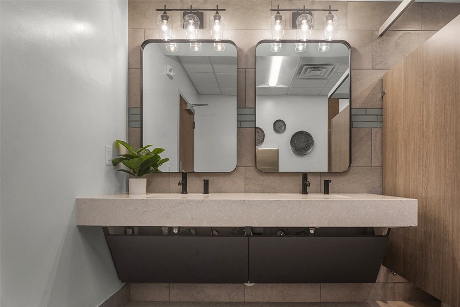 a bathroom with two sinks and two mirrors