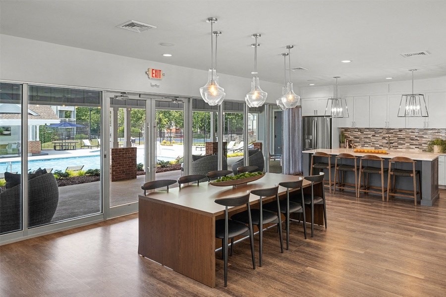 a large dining room with a large table and chairs in front of a pool