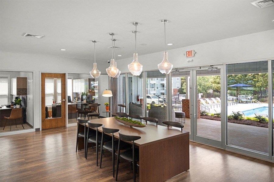 a large dining room with a large table and chairs and a view of a pool