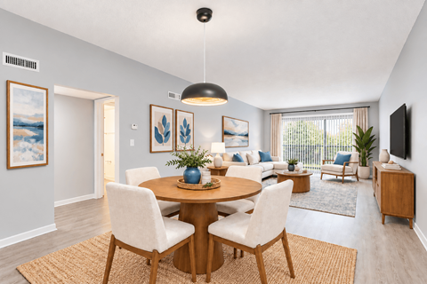 A dining room with a round table and chairs.