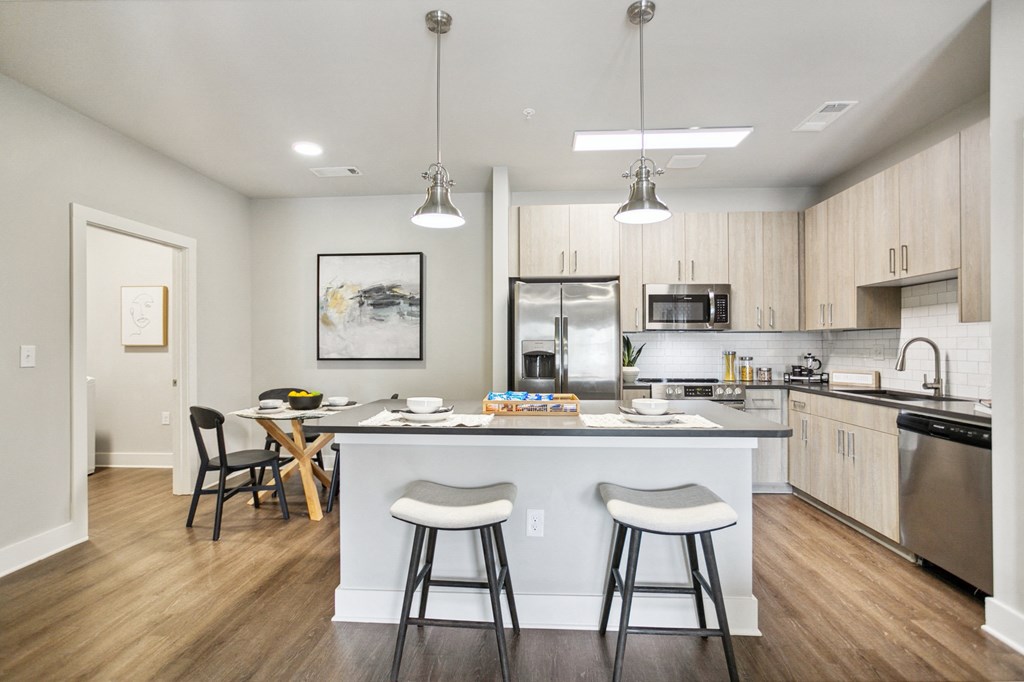 an open kitchen and dining area with a large island and stools