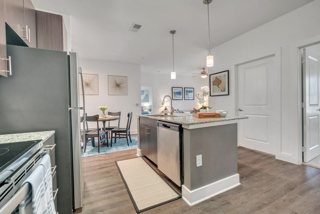 an open kitchen and dining room with stainless steel appliances and a counter top