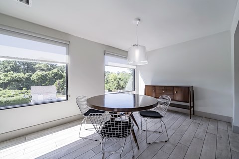 A dining room with a round table and chairs.