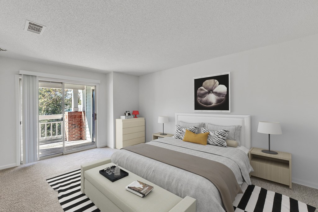 A bedroom with a bed, nightstand, and a painting on the wall.